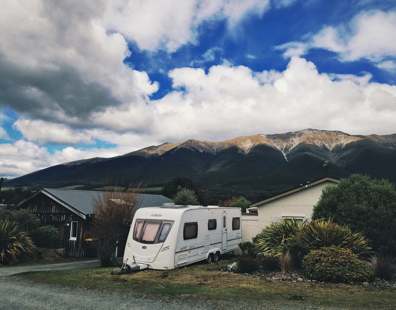 A touring caravan with New Zealand mountains behind